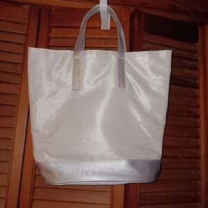 Pearl white bag with silver bottom and silver straps with plastic still on them.